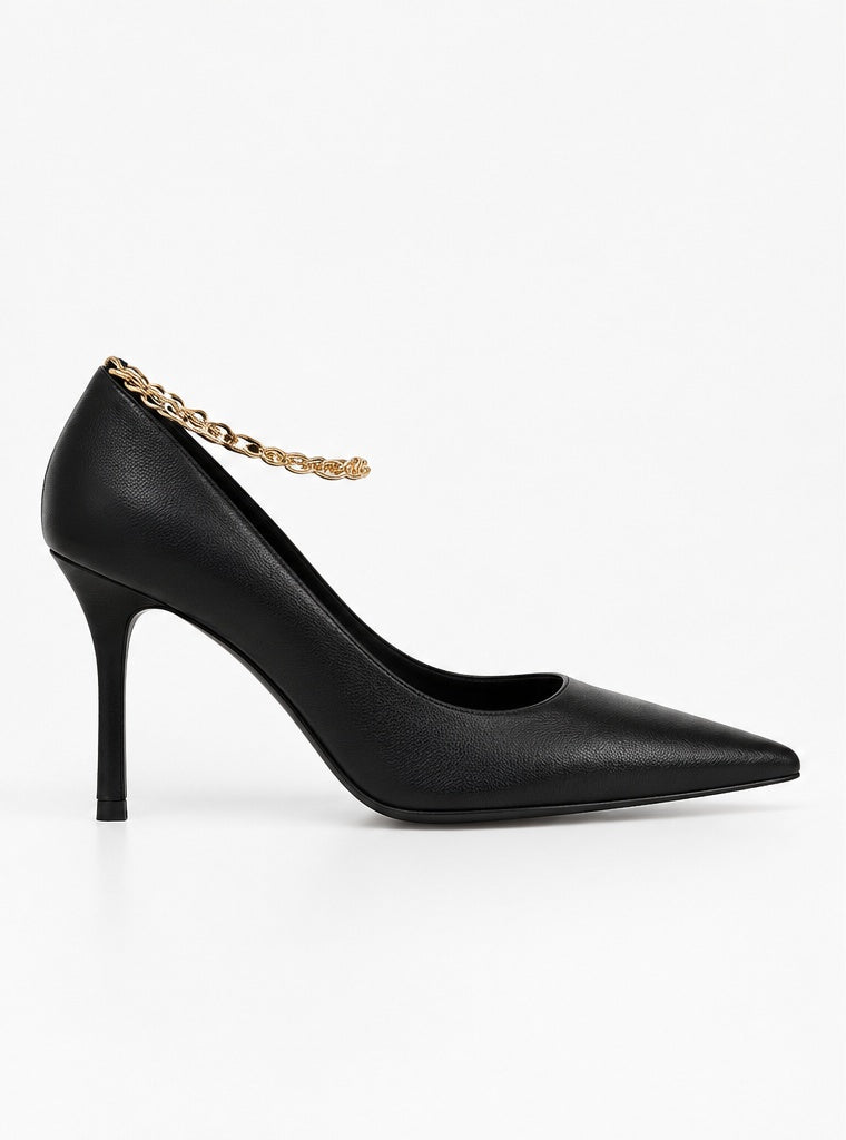 Side profile of The Chain Pump, a black sheepskin leather stiletto pump with a gold-tone chain at the ankle